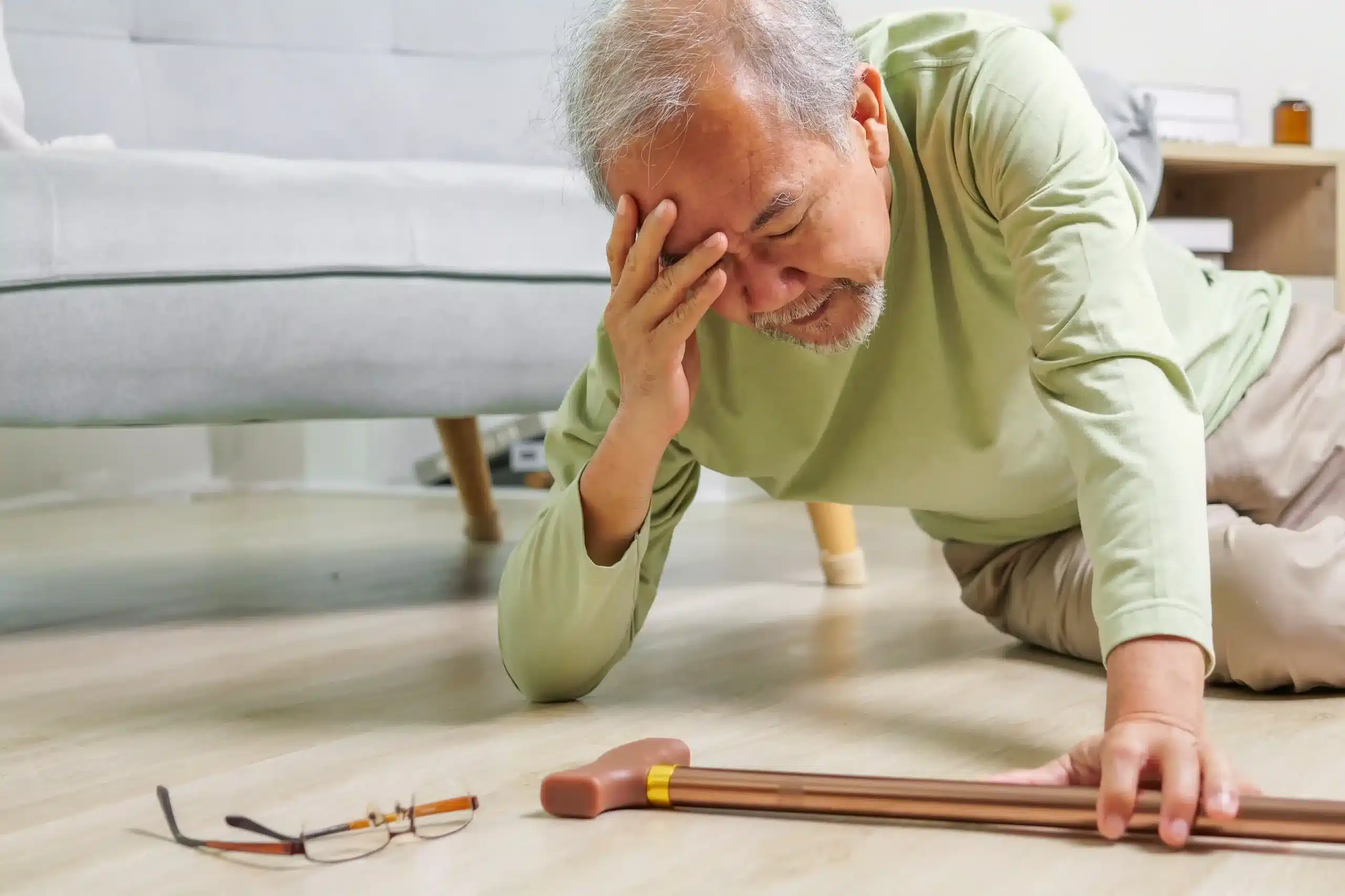 Elderly resident using a walker in a nursing home hallway, highlighting fall risks and safety concerns