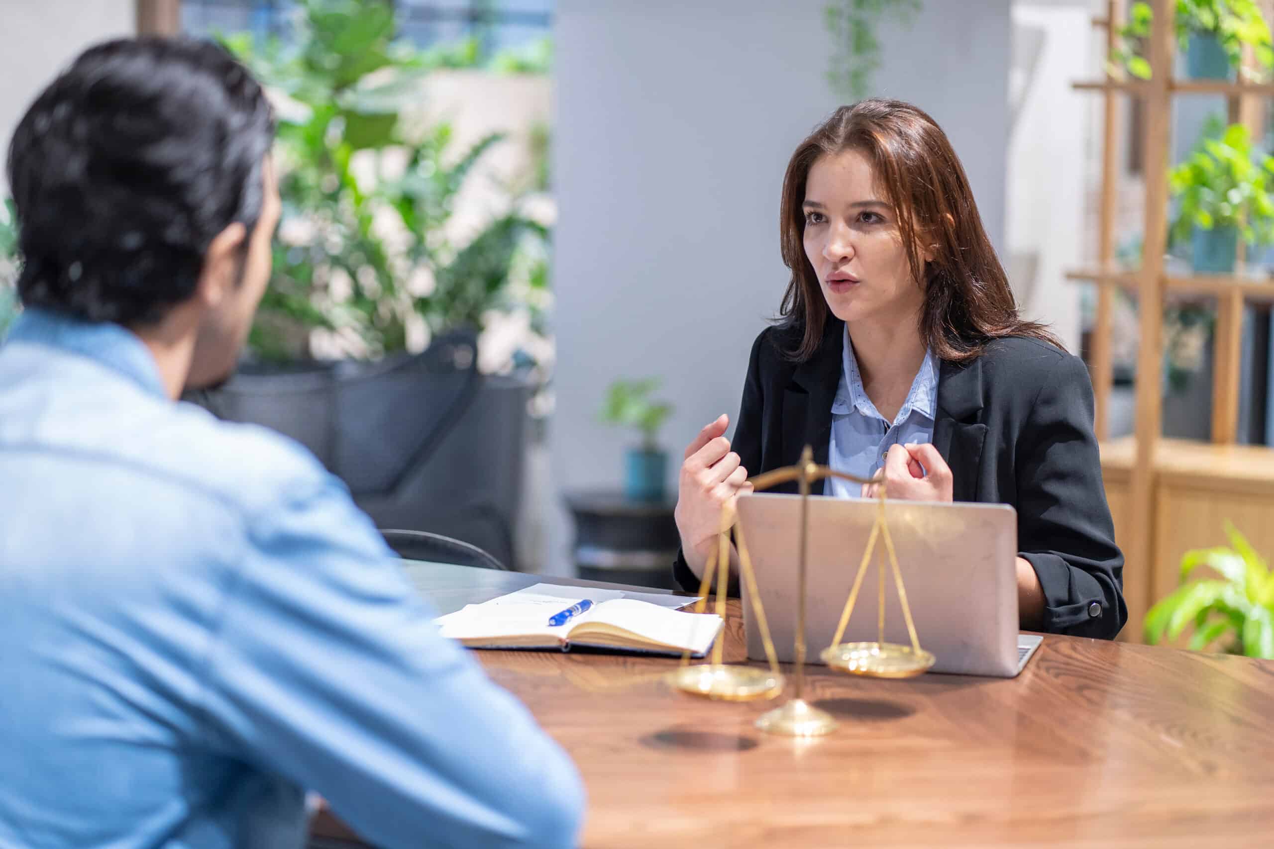 Young lawyer giving legal advice to a male client during a premises liability consultation in a law office
