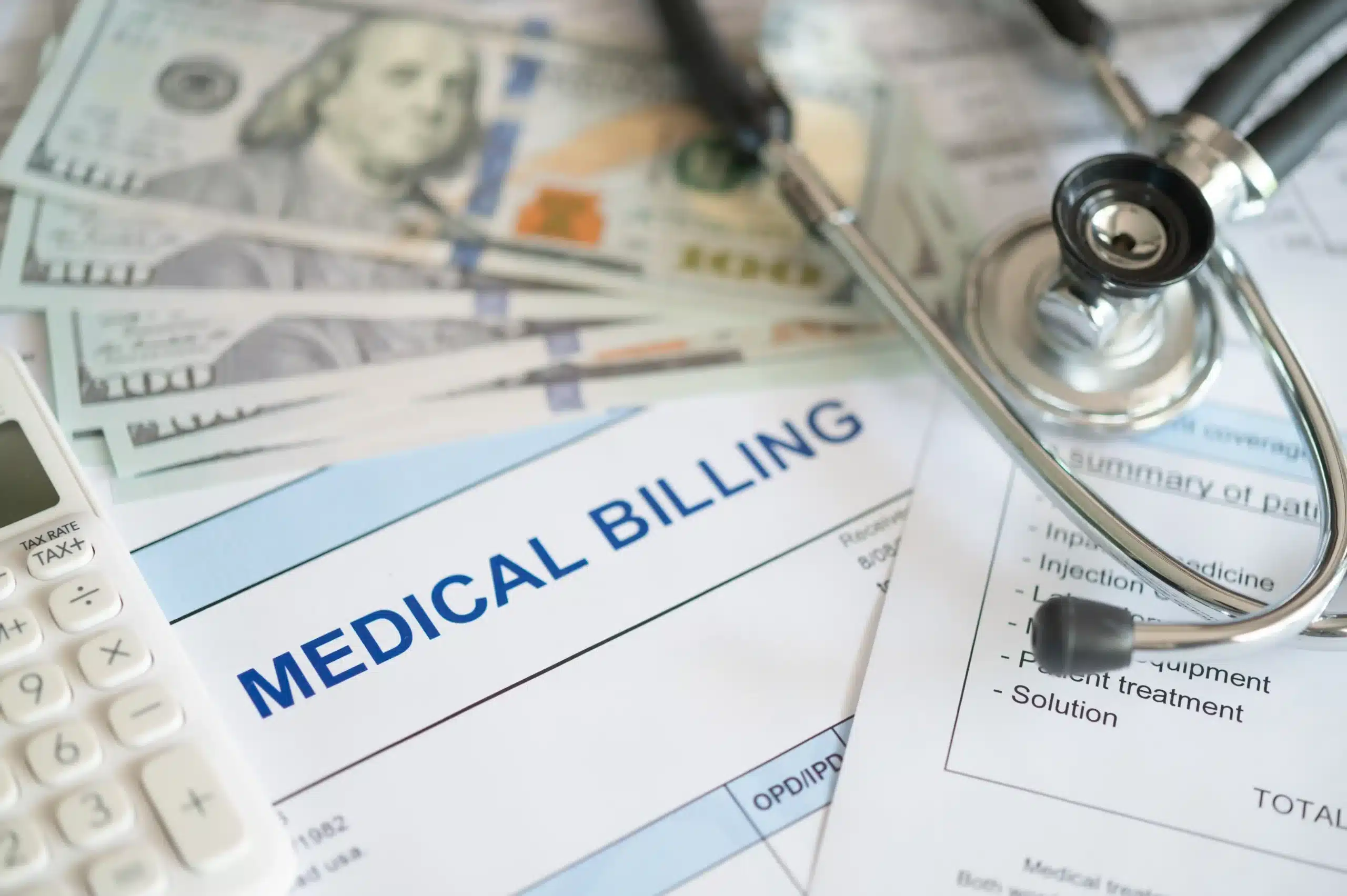 Medical billing documents with a calculator, dollar bills, and stethoscope representing medical expenses and injury claim damages